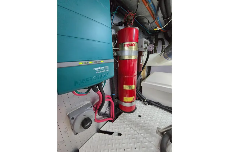 Slide: The Image of Engine room of 2004 Grand Harbour 58 with fire extinguisher and electrical components. - 125