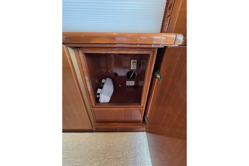 Slide: The Image of Open wooden cabinet on 2004 Grand Harbour 58 yacht, revealing electrical outlets and storage space. - 18