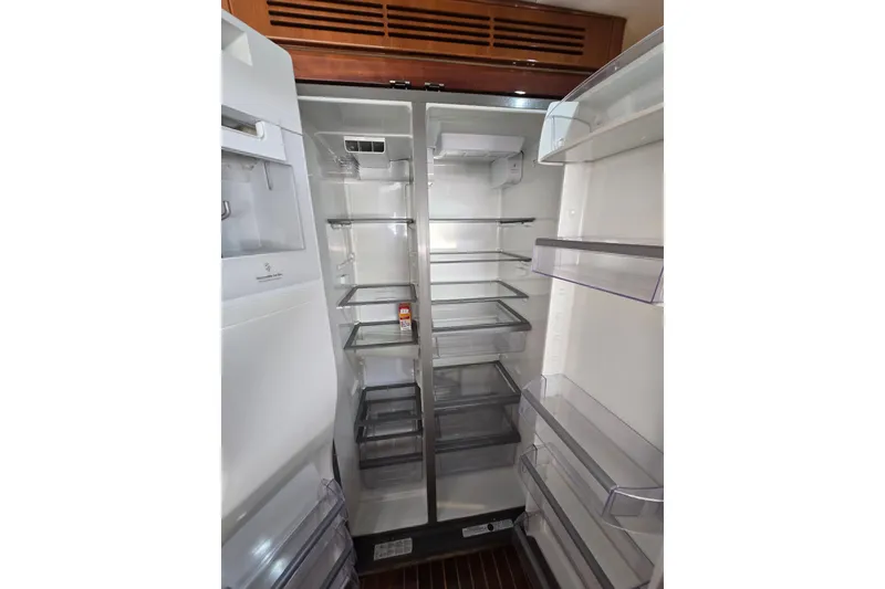 Slide: The Image of Empty refrigerator interior on a 2004 Grand Harbour 58 yacht, showcasing spacious shelving. - 37