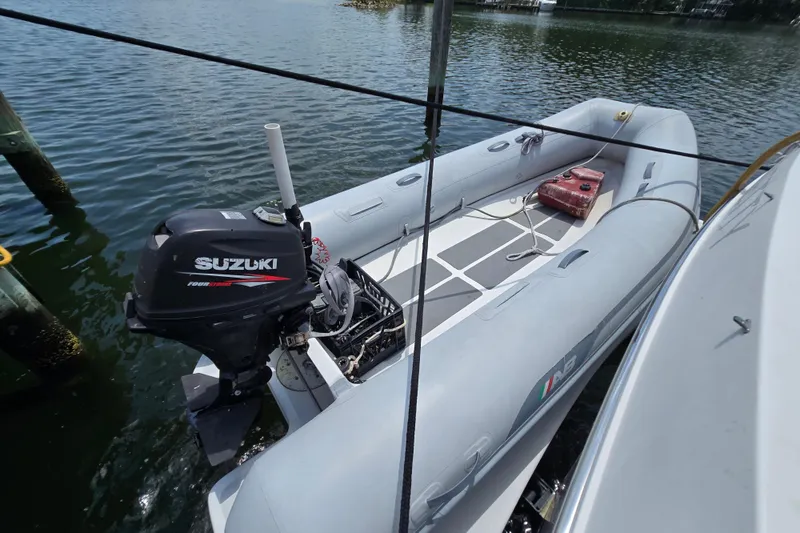 Slide: The Image of Inflatable boat with Suzuki outboard motor, docked beside a Grand Harbour 58 yacht, 2004 model. - 134