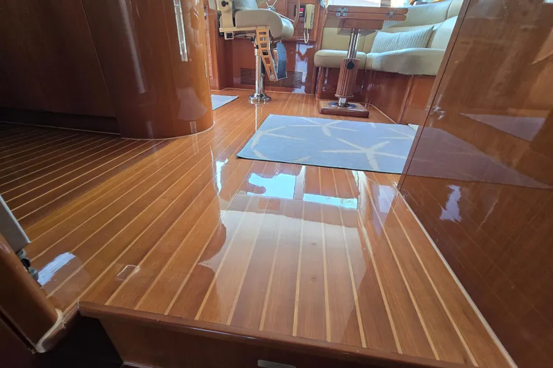 Slide: The Image of Luxurious wooden interior of a 2004 Grand Harbour 58 yacht, featuring polished floors and elegant seating. - 20