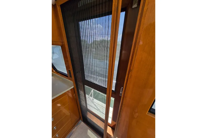 Slide: The Image of Interior view of 2004 Grand Harbour 58 yacht with wooden cabinetry and sliding door. - 77