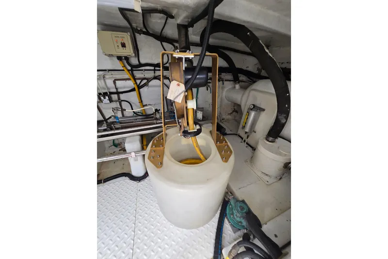 Slide: The Image of Engine room of 2004 Grand Harbour 58 yacht, featuring mechanical components and piping. - 113