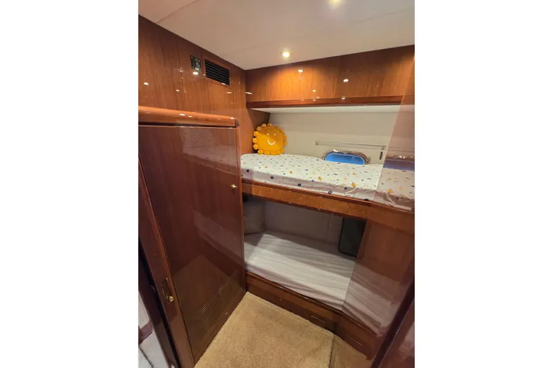 Slide: The Image of Luxurious 2004 Grand Harbour 58 yacht cabin with wooden finish and cozy bunk beds. - 63