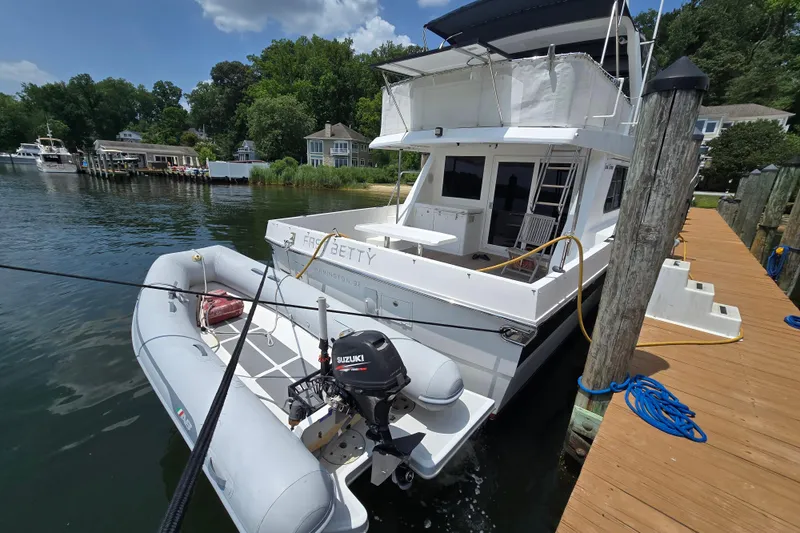 Slide: The Image of Grand Harbour 58 yacht from 2004 docked with inflatable boat and Suzuki motor. - 4