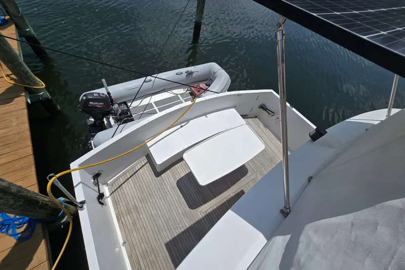 Slide: The Image of Grand Harbour 58 yacht stern with dinghy and Suzuki outboard motor, docked at marina. - 87