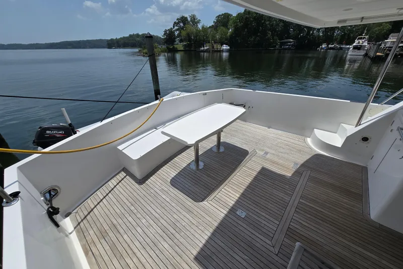 Slide: The Image of Spacious deck of 2004 Grand Harbour 58 yacht with wooden flooring and seating area. - 7