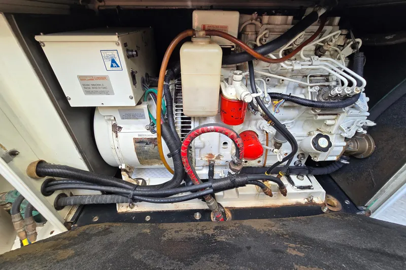 Slide: The Image of Engine compartment of a 2004 Grand Harbour 58 yacht, showcasing mechanical components and wiring. - 110