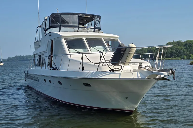 Slide: The Image of 2004 Grand Harbour 58 yacht on calm water, featuring sleek design and spacious deck. - 3