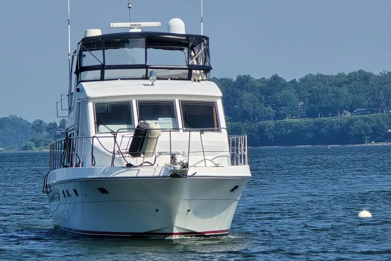 Slide: The Image of 2004 Grand Harbour 58 yacht on calm water with scenic forested shoreline. - 1
