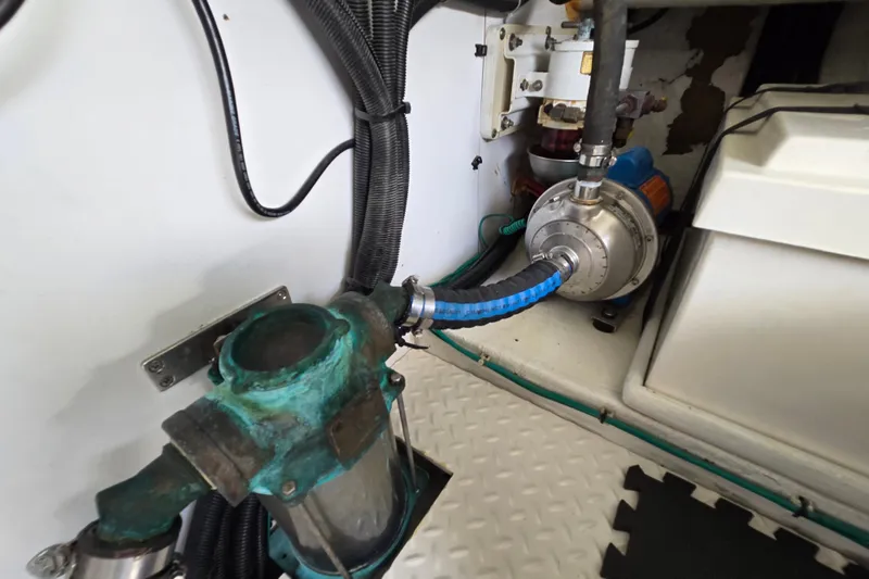 Slide: The Image of Engine room of 2004 Grand Harbour 58 yacht, featuring mechanical components and hoses. - 129