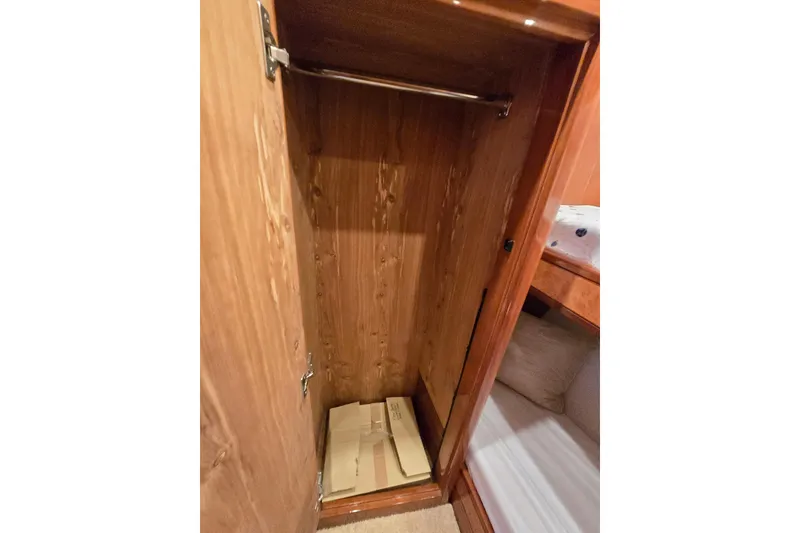 Slide: The Image of Empty wooden closet inside a 2004 Grand Harbour 58 yacht, featuring a hanging rod. - 65