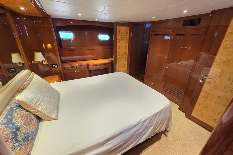 Slide: The Image of Luxurious 2004 Grand Harbour 58 yacht bedroom with elegant wood finishes and cozy bedding. - 56