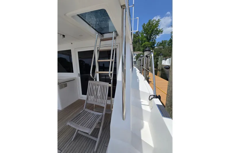 Slide: The Image of Side deck of 2004 Grand Harbour 58 yacht with ladder and wooden chair. - 8