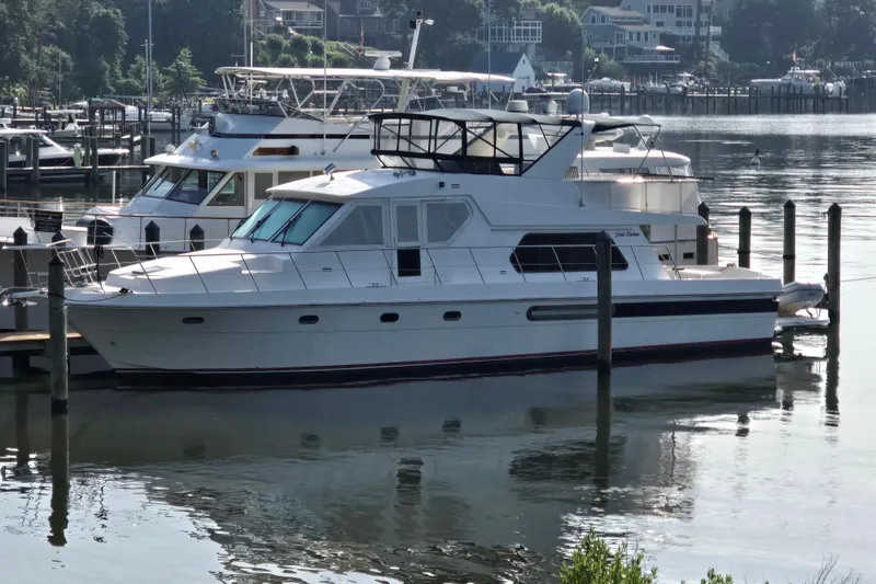 The Image of 2004 Grand Harbour 58 yacht docked at a marina, reflecting on calm water. - 0