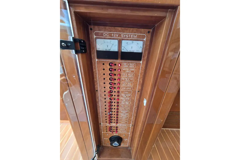 Slide: The Image of DC 12V system panel on 2004 Grand Harbour 58 yacht, featuring voltmeter and circuit switches. - 32