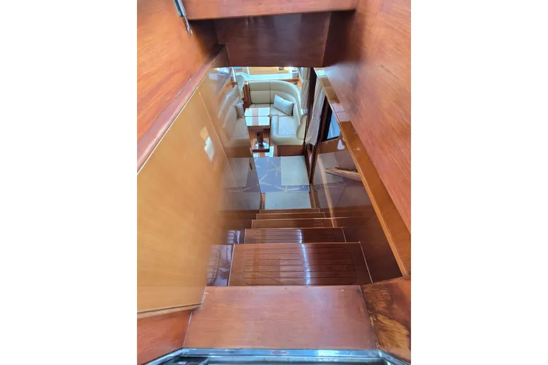 Slide: The Image of Interior view of 2004 Grand Harbour 58 yacht, featuring wooden stairs and a cozy seating area. - 98