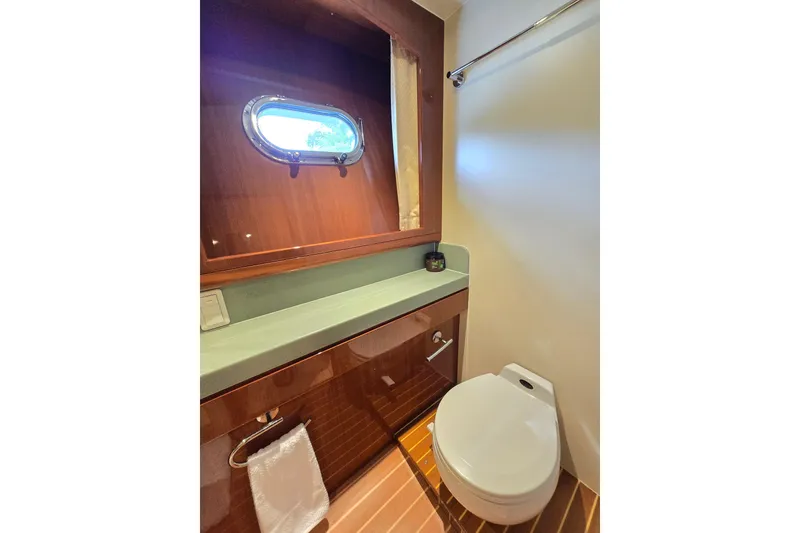 Slide: The Image of Luxurious bathroom in 2004 Grand Harbour 58 yacht with wooden accents and porthole window. - 51