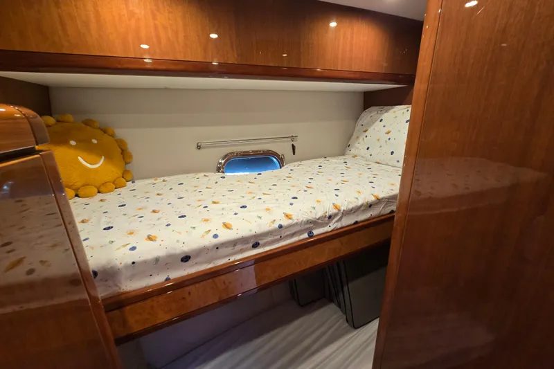 Slide: The Image of Cozy cabin bed in 2004 Grand Harbour 58 yacht with wooden finish and decorative pillow. - 64