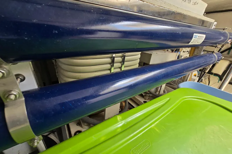 Slide: The Image of Engine room of a 2004 Grand Harbour 58 yacht, featuring blue pipes and equipment. - 131