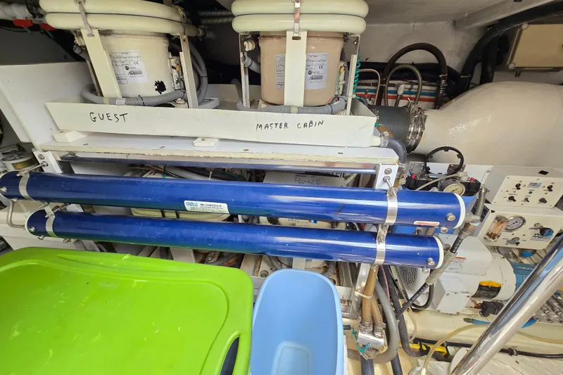 Slide: The Image of Engine room of a 2004 Grand Harbour 58 yacht, featuring labeled equipment and piping. - 105