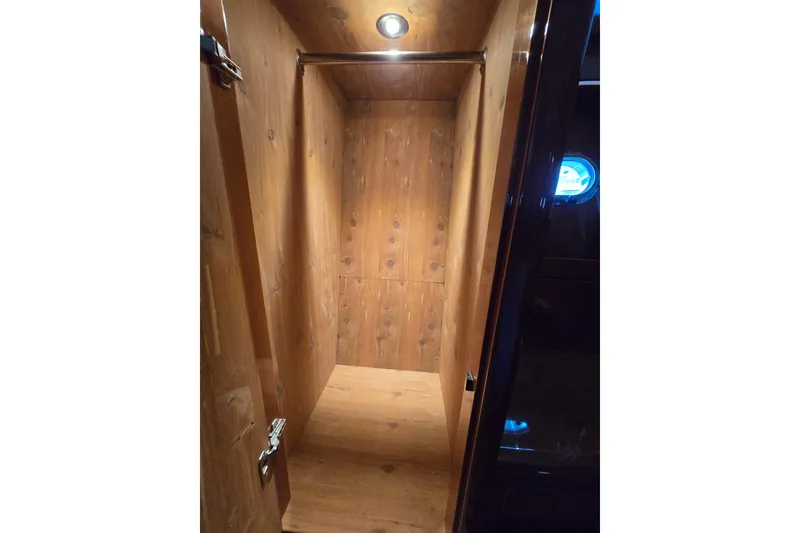 Slide: The Image of Wooden interior closet on 2004 Grand Harbour 58 yacht, featuring a hanging rod and spotlight. - 59