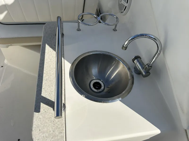 Slide: The Image of A stainless steel sink with a faucet on a boat, surrounded by white upholstery and holders. - 25