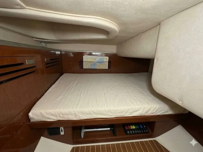 Slide: The Image of Interior of a 2010 Sea Ray Sundancer 260 featuring a cozy bed and wood accents. - 5