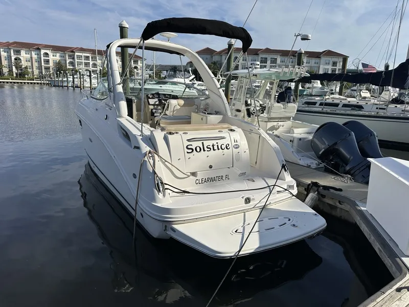 Slide: The Image of A 2010 Sea Ray Sundancer 260 docked in a marina. It features a sleek, white design. - 12