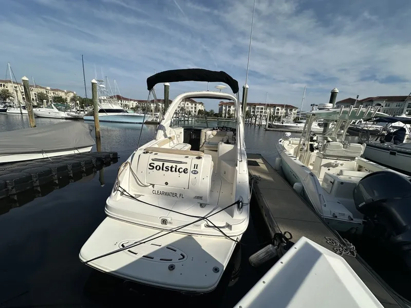 Slide: The Image of A 2010 Sea Ray Sundancer 260 docked at a marina, surrounded by other boats. - 13