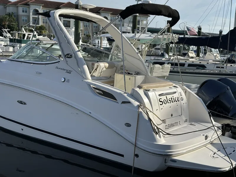 Slide: The Image of A 2010 Sea Ray Sundancer 260 is docked. It features a sleek, white design. - 9