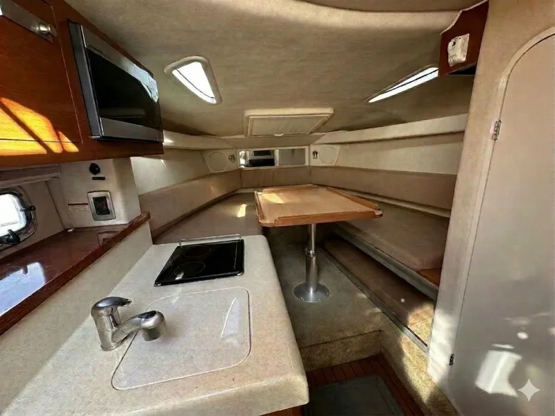 Slide: The Image of Interior of a 2010 Sea Ray Sundancer 260 with a kitchenette and dining area. - 3