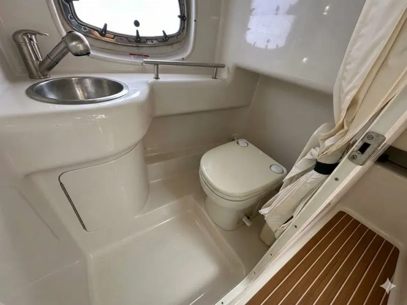 Slide: The Image of The image shows a boat bathroom with a toilet, sink, and porthole. - 6