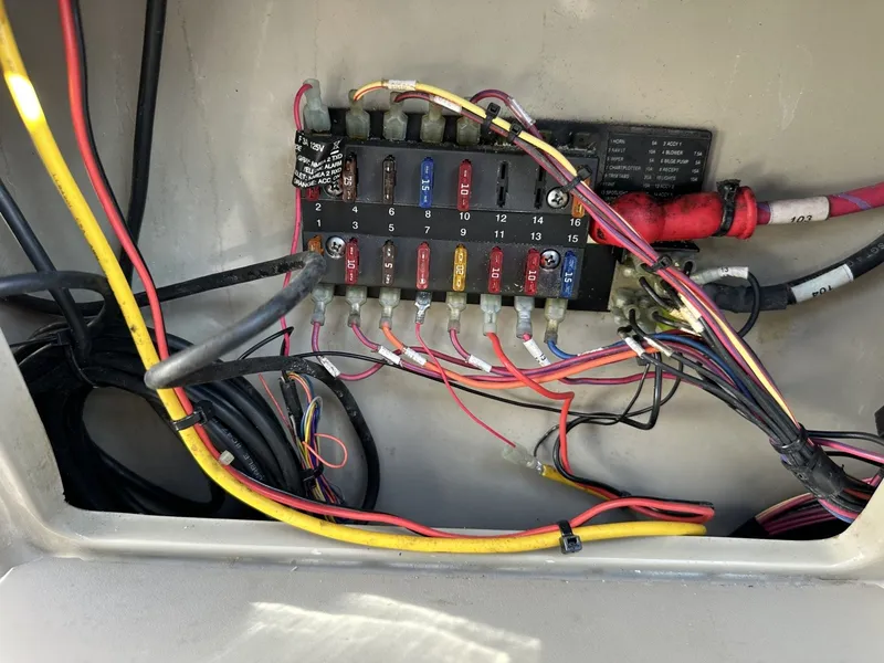 Slide: The Image of A fuse box with multiple colored wires inside a boat. - 49