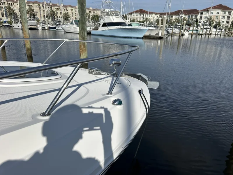 Slide: The Image of Bow of a Sea Ray Sundancer 260 boat in a marina, with water and other boats in the background. - 14