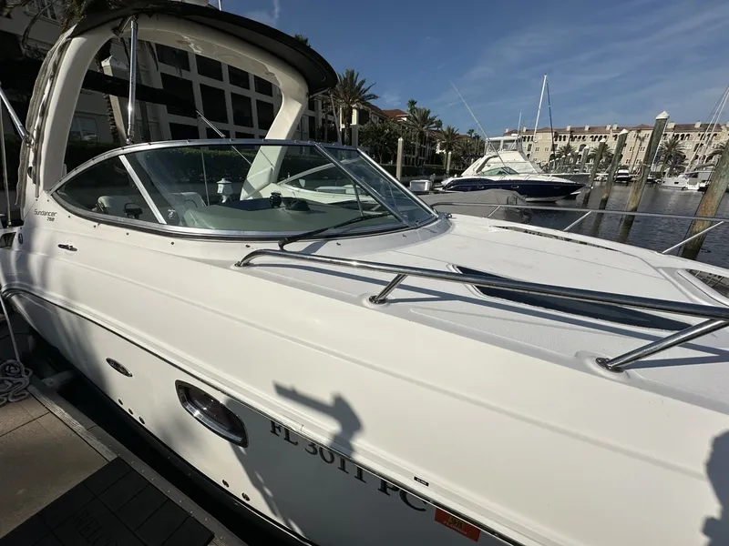 Slide: The Image of 2010 Sea Ray Sundancer 260 docked, featuring a sleek white hull and modern lines. - 16