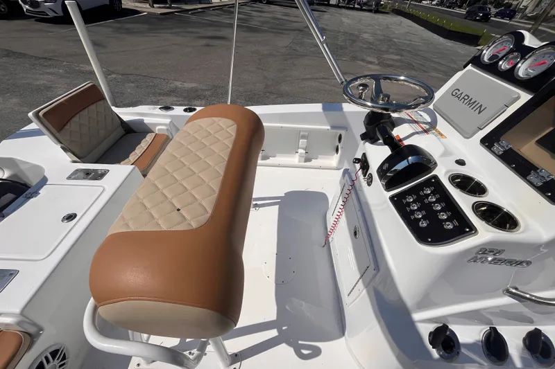 Slide: The Image of 2025 NauticStar 191 Hybrid boat interior with tan seating and Garmin navigation system. - 7