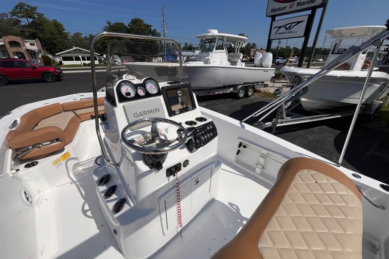 Slide: The Image of 2025 NauticStar 191 Hybrid boat interior with Garmin navigation, tan seating, and steering console. - 14