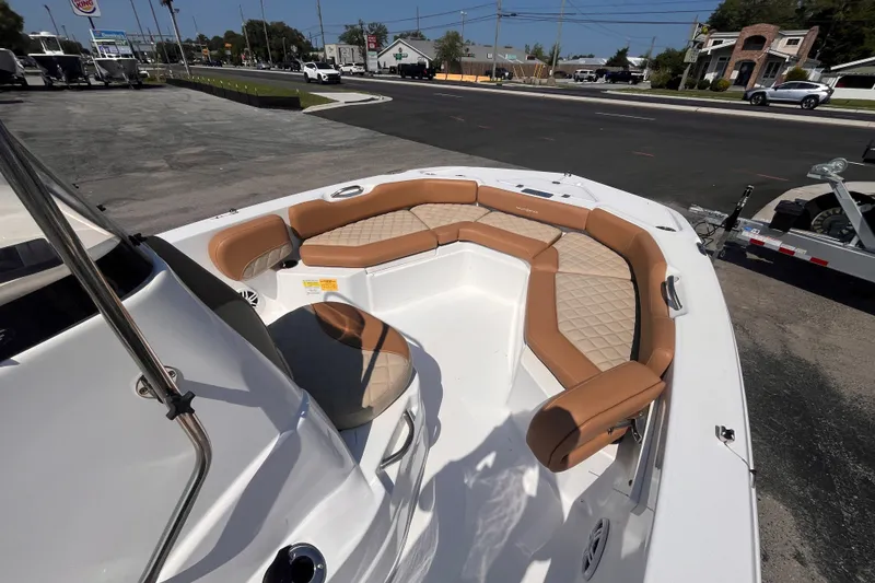 Slide: The Image of 2025 NauticStar 191 Hybrid boat with tan seating, parked on a street. - 9