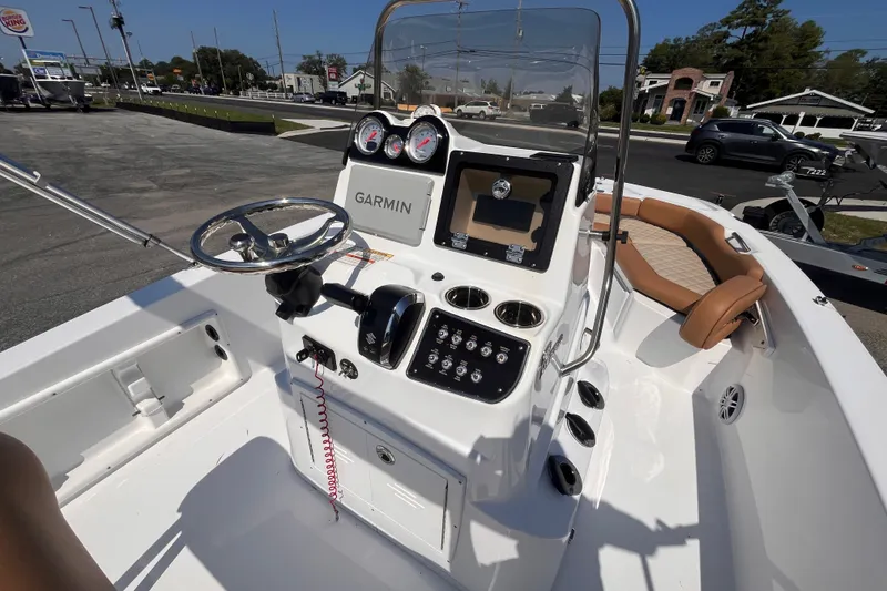 Slide: The Image of 2025 NauticStar 191 Hybrid boat interior with Garmin navigation, steering wheel, and seating. - 8