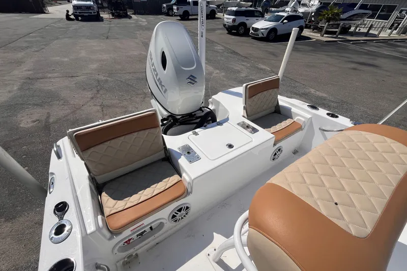 Slide: The Image of 2025 NauticStar 191 Hybrid boat interior with tan seating and Suzuki outboard motor. - 6