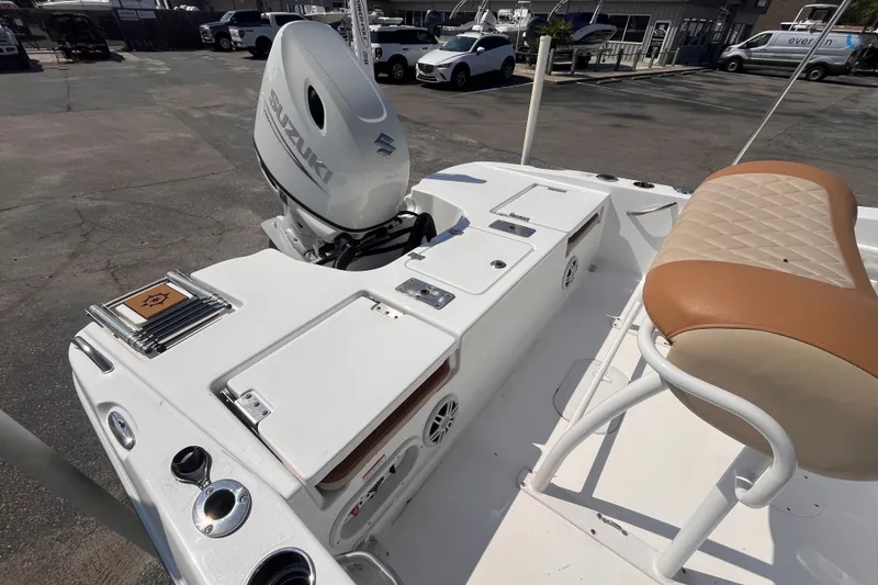 Slide: The Image of 2025 NauticStar 191 Hybrid boat with Suzuki outboard motor, featuring tan seating and storage compartments. - 5