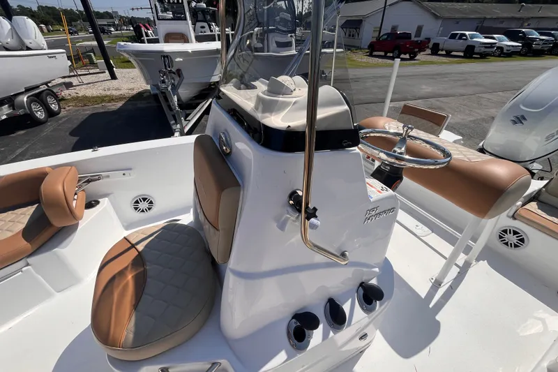 Slide: The Image of 2025 NauticStar 191 Hybrid boat interior with tan seating and steering console. - 12