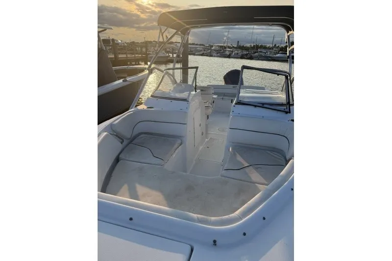 Slide: The Image of 2014 Sea Hunt Escape 234 LE boat interior at sunset, docked in a marina. - 17