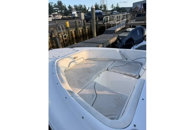 Slide: The Image of 2014 Sea Hunt Escape 234 LE boat interior at dock, featuring spacious seating area. - 14