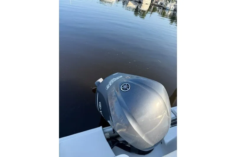 Slide: The Image of Outboard motor on a 2014 Sea Hunt Escape 234 LE boat by the water. - 19