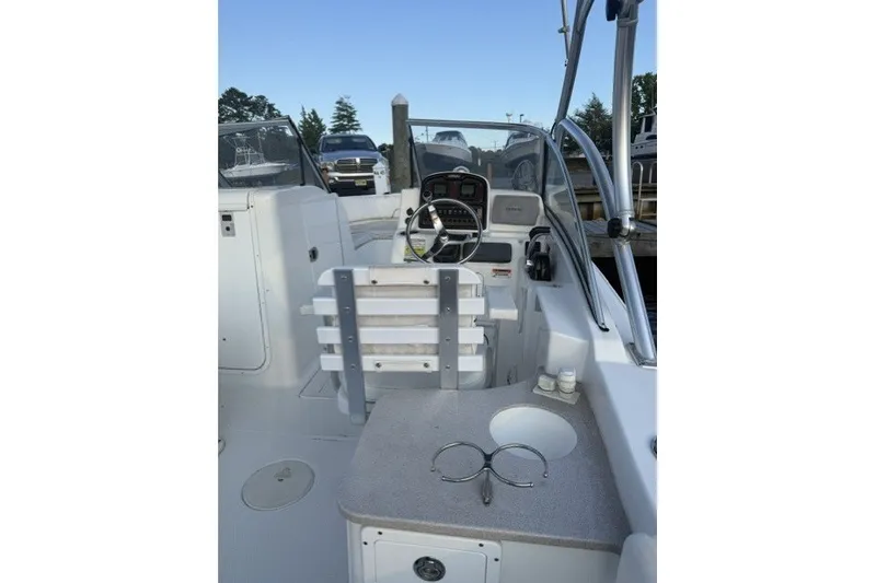 Slide: The Image of 2014 Sea Hunt Escape 234 LE boat interior with steering wheel and seating area. - 15