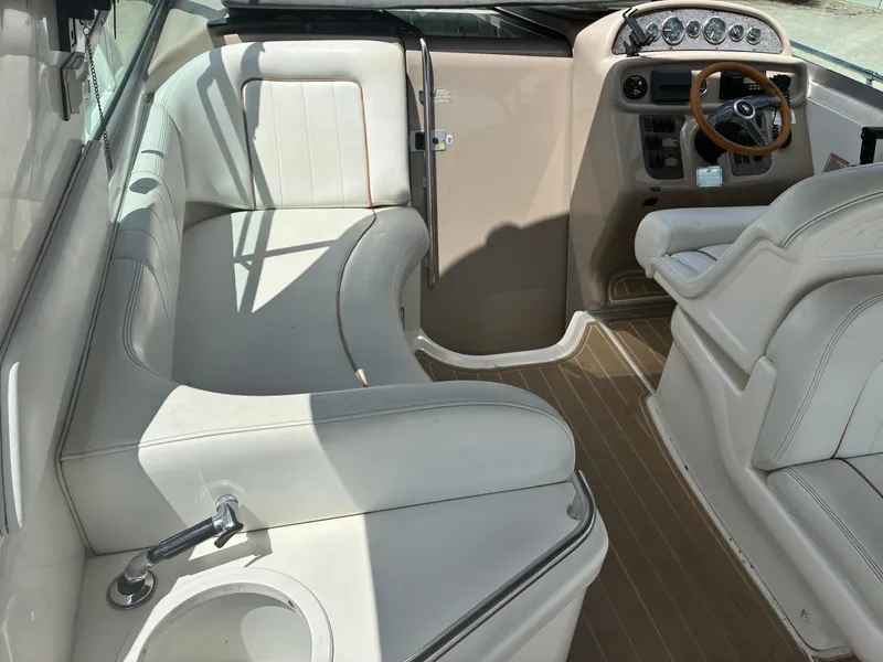 Slide: The Image of The image shows the cockpit of a 1998 Sea Ray 290 Sundancer with white leather seating and a helm. - 9