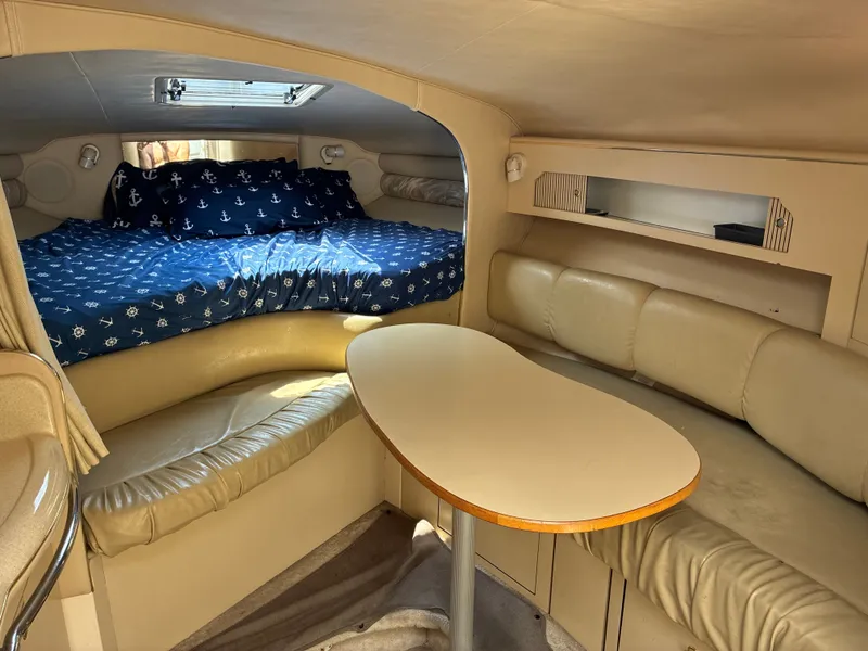Slide: The Image of Interior of a 1998 Sea Ray 290 Sundancer with cozy seating area and sleeping space. - 13