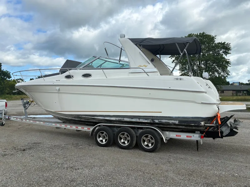 Slide: The Image of A 1998 Sea Ray 290 Sundancer on a trailer, featuring a black canopy. - 6
